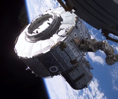 The International Space Station's robot arm, operated by Expedition 2 Flight Engineer Susan Helms, moves the Joint Airlock into position