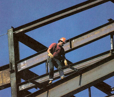 A steel worker balances on the framework of a building for the Los Angeles County Museum of Natural History