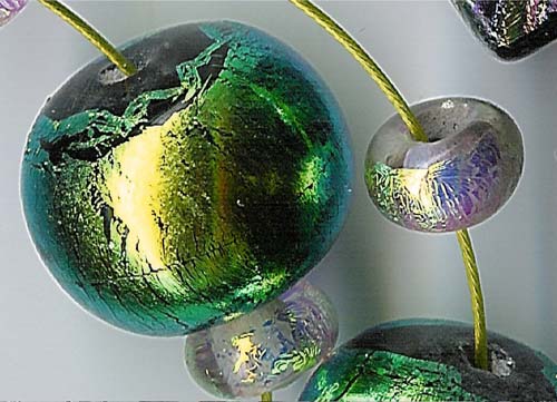 Lampworked dichroic glass bead.
