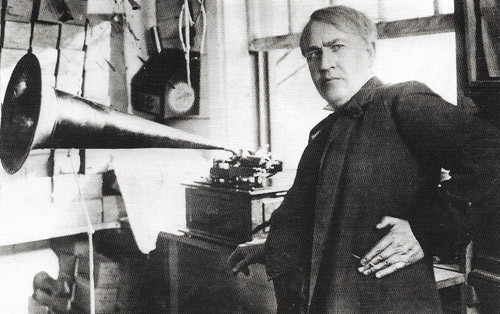 Thomas Edison, photographed.with a commercial descendant of his 1877 cylinder phonograph.