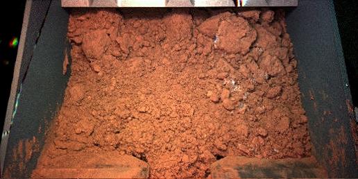 Material from the martian surface captured by the Robotic Arm (RA) scoop during its first test dig and dump on the seventh martian day of the mission (June 1, 2008)