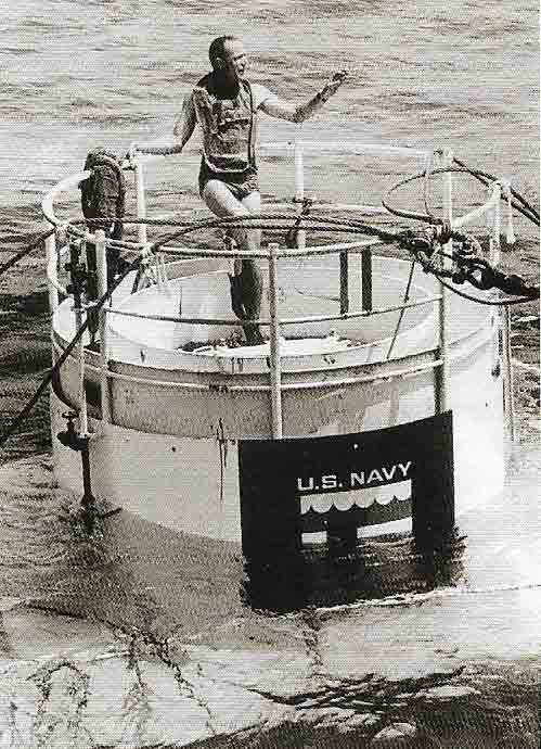 Aquanaut Scott Carpenter stands atop SEALAB II and gives the signal for it to be lowered in 1965.